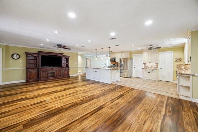 7506 Dearborn St, Houston, TX 77055 - unfurnished living room featuring ceiling fan, ornamental molding, recessed lighting, a sink, and baseboards