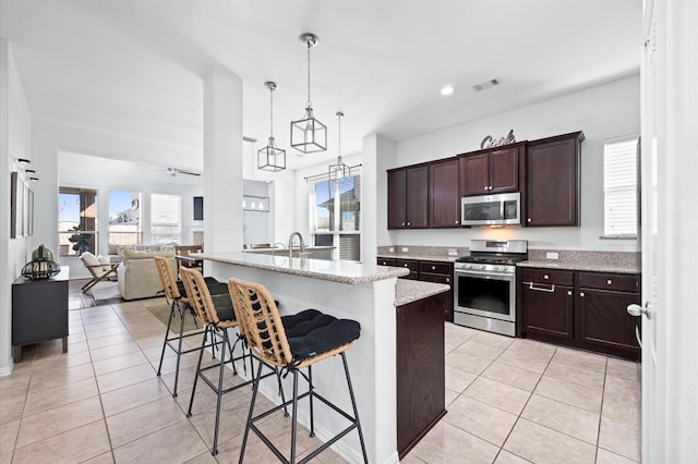 2807 Hadley Spgs, Spring, TX 77386 - kitchen featuring appliances with stainless steel finishes, light tile patterned floors, plenty of natural light, dark brown cabinets, and recessed lighting
