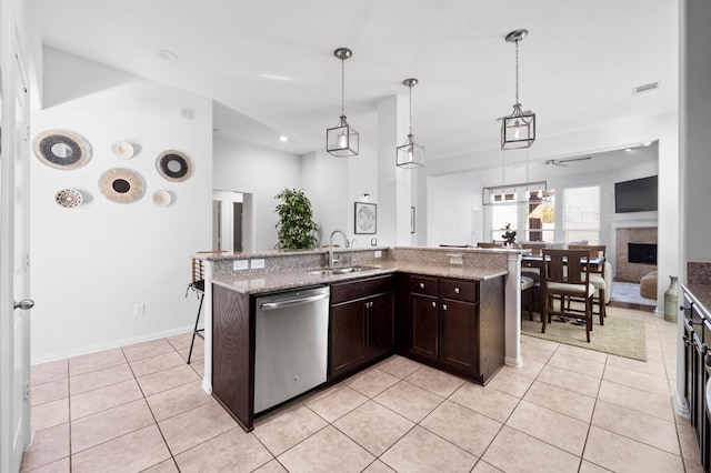 2807 Hadley Spgs, Spring, TX 77386 - kitchen featuring dishwasher, a sink, dark brown cabinets, light tile patterned flooring, and a fireplace