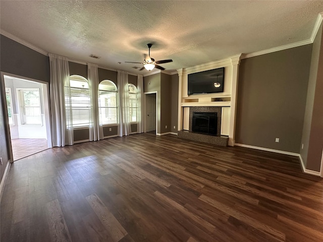 243 Fantasy Ln, Montgomery, TX 77356 - unfurnished living room featuring a textured ceiling, a ceiling fan, ornamental molding, dark wood-style floors, and a fireplace with raised hearth