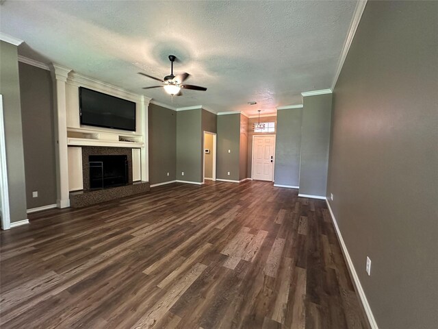 243 Fantasy Ln, Montgomery, TX 77356 - unfurnished living room with dark wood finished floors, ornamental molding, ceiling fan, baseboards, and a textured ceiling