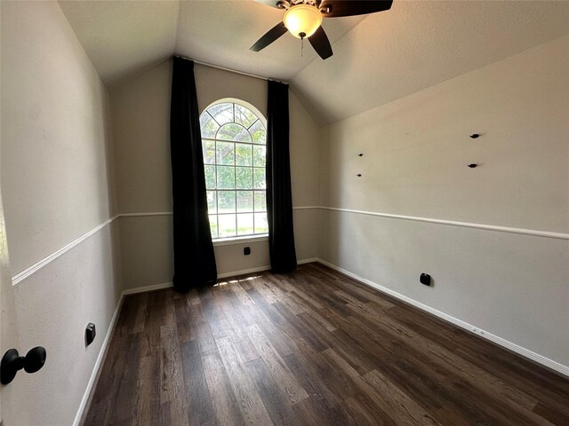 243 Fantasy Ln, Montgomery, TX 77356 - spare room with dark wood-style flooring, vaulted ceiling, a ceiling fan, and baseboards
