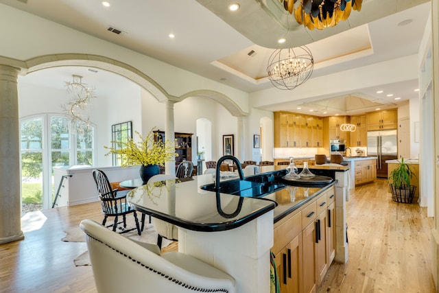 115 Hidden Hills Dr, Spicewood, TX 78669 - kitchen featuring decorative columns, stainless steel appliances, dark countertops, light brown cabinets, and recessed lighting