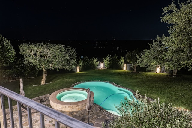 115 Hidden Hills Dr, Spicewood, TX 78669 - pool at night featuring an in-ground hot tub and a lawn
