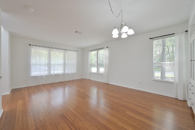 3 Shallow Pond Ct, The Woodlands, TX 77381 - spare room featuring a chandelier, wood finished floors, and healthy amount of natural light