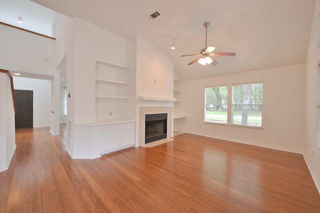 3 Shallow Pond Ct, The Woodlands, TX 77381 - unfurnished living room featuring built in shelves, a fireplace, ceiling fan, light wood finished floors, and baseboards