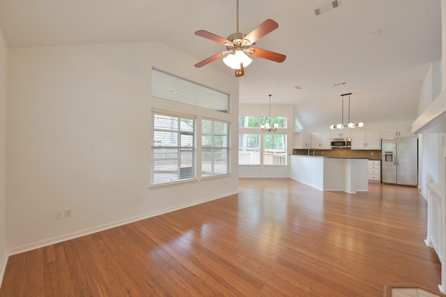 3 Shallow Pond Ct, The Woodlands, TX 77381 - unfurnished living room featuring a chandelier, vaulted ceiling, light wood finished floors, ceiling fan, and baseboards