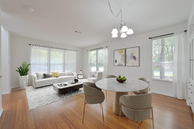 3 Shallow Pond Ct, The Woodlands, TX 77381 - dining area featuring plenty of natural light, wood finished floors, a chandelier, and baseboards