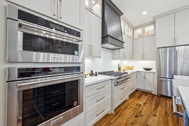 1518 31st St, Galveston, TX 77550 - kitchen with stainless steel appliances, custom exhaust hood, light countertops, wood finished floors, and recessed lighting