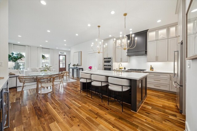 1518 31st St, Galveston, TX 77550 - kitchen featuring custom range hood, wood-type flooring, stainless steel appliances, a chandelier, and recessed lighting