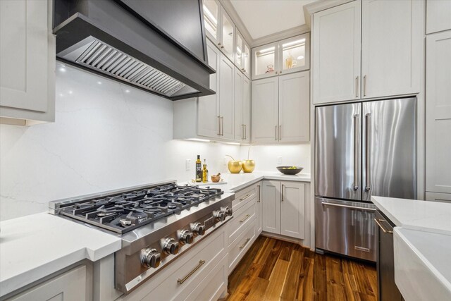1518 31st St, Galveston, TX 77550 - kitchen featuring custom exhaust hood, stainless steel appliances, dark wood finished floors, glass insert cabinets, and white cabinetry