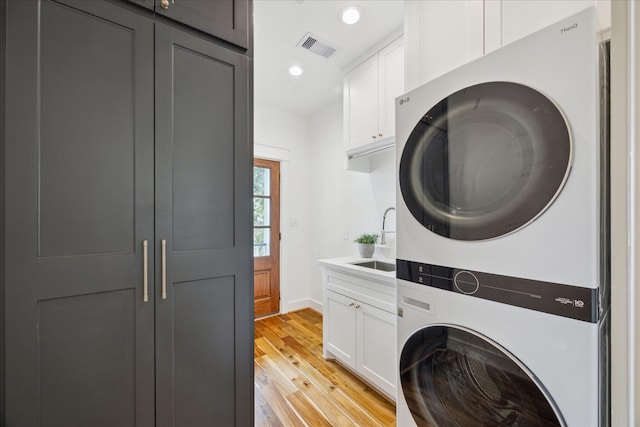 1518 31st St, Galveston, TX 77550 - washroom featuring stacked washing machine and dryer, cabinet space, light wood-style floors, baseboards, and recessed lighting