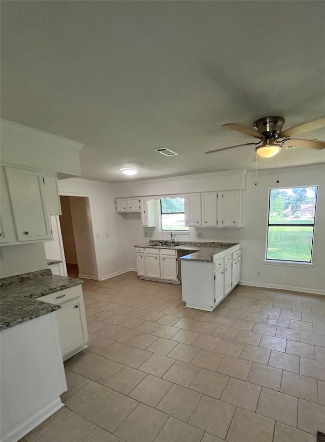 169 W Sunset Dr, Trinity, TX 75862 - kitchen featuring baseboards, a sink, and white cabinetry