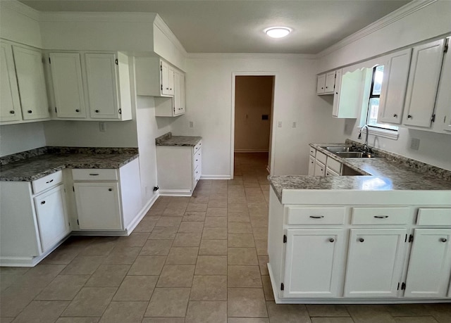 169 W Sunset Dr, Trinity, TX 75862 - kitchen featuring a sink, a peninsula, baseboards, white cabinets, and ornamental molding