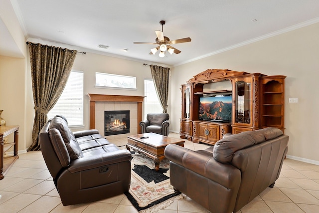 12822 Winding Manor Dr, Houston, TX 77044 - living room with a ceiling fan, a tiled fireplace, light tile patterned flooring, baseboards, and ornamental molding