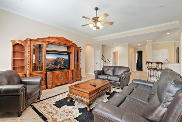 12822 Winding Manor Dr, Houston, TX 77044 - living room with arched walkways, ceiling fan, light tile patterned floors, stairs, and crown molding