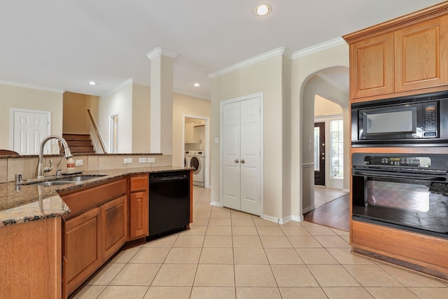 12822 Winding Manor Dr, Houston, TX 77044 - kitchen with black appliances, a sink, washer / clothes dryer, stone counters, and light tile patterned floors