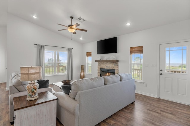 1023 N Bay St, Gilchrist, TX 77617 - living area featuring a ceiling fan, plenty of natural light, lofted ceiling, a stone fireplace, and dark wood-style floors