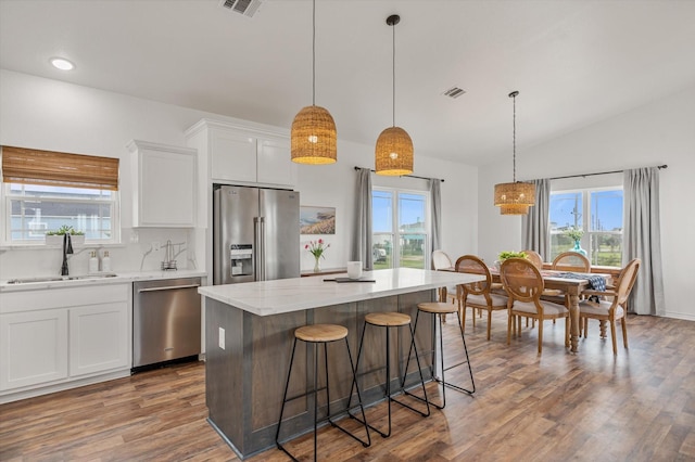 1023 N Bay St, Gilchrist, TX 77617 - kitchen featuring stainless steel appliances, a sink, healthy amount of natural light, wood finished floors, and vaulted ceiling