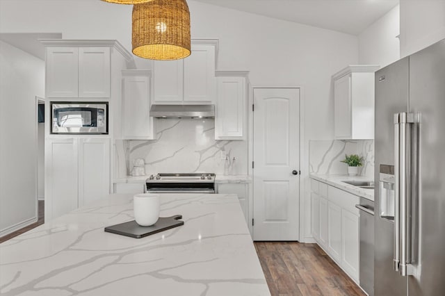 1023 N Bay St, Gilchrist, TX 77617 - kitchen with stainless steel appliances, extractor fan, white cabinets, and backsplash