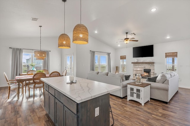 1023 N Bay St, Gilchrist, TX 77617 - kitchen featuring lofted ceiling, ceiling fan, a fireplace, dark wood finished floors, and a kitchen island