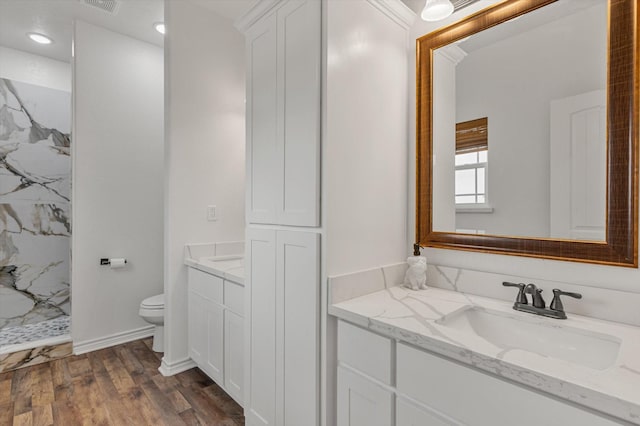 1023 N Bay St, Gilchrist, TX 77617 - bathroom featuring toilet, vanity, a marble finish shower, and wood finished floors