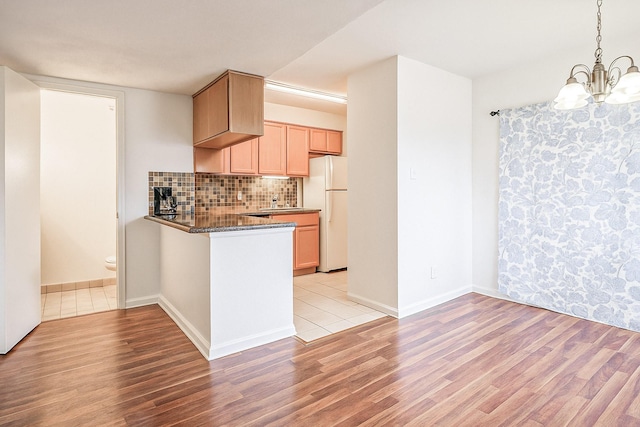 515 Tallowood Rd Unit 1, Houston, TX 77024 - kitchen featuring freestanding refrigerator, light wood-style flooring, a chandelier, and decorative backsplash