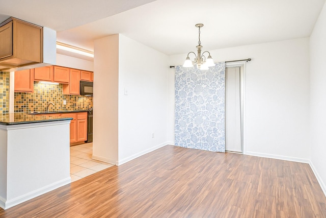 515 Tallowood Rd Unit 1, Houston, TX 77024 - unfurnished dining area with a chandelier, light wood-style floors, baseboards, and a sink