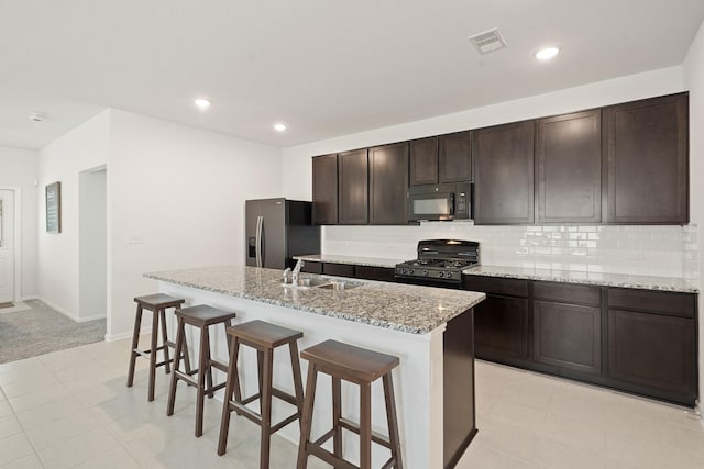 12022 Fletching Stone Ln, Houston, TX 77044 - kitchen with black appliances, an island with sink, a sink, a breakfast bar, and backsplash