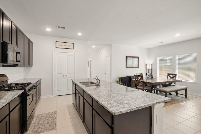 12022 Fletching Stone Ln, Houston, TX 77044 - kitchen with black appliances, a sink, an island with sink, light tile patterned floors, and recessed lighting
