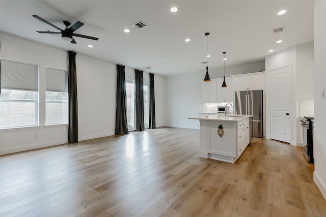 7810 Kenton St, Houston, TX 77028 - kitchen with open floor plan, stainless steel appliances, ceiling fan, recessed lighting, and a center island with sink