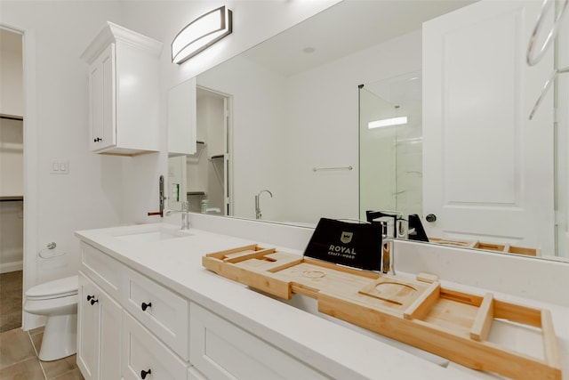 7810 Kenton St, Houston, TX 77028 - bathroom featuring toilet, double vanity, a spacious closet, a shower, and tile patterned flooring