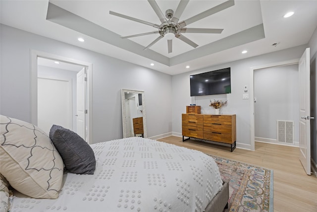 18215 Hereford Ln, Houston, TX 77058 - bedroom with a tray ceiling, light wood-style flooring, baseboards, recessed lighting, and connected bathroom