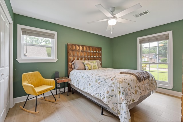 18215 Hereford Ln, Houston, TX 77058 - bedroom with multiple windows, baseboards, a closet, and light wood finished floors