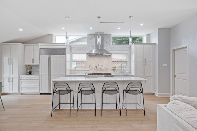 18215 Hereford Ln, Houston, TX 77058 - kitchen featuring wall chimney range hood, paneled fridge, decorative backsplash, light countertops, and lofted ceiling