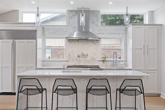 18215 Hereford Ln, Houston, TX 77058 - kitchen featuring paneled built in refrigerator, wall chimney exhaust hood, a sink, decorative backsplash, and recessed lighting