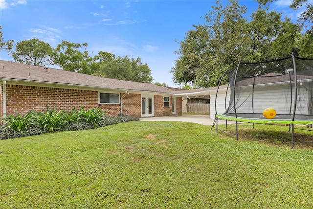 18215 Hereford Ln, Houston, TX 77058 - back of house with a trampoline, french doors, brick siding, concrete driveway, and a patio