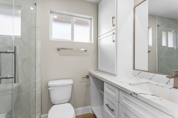 10719 Carlota Ct, Houston, TX 77096 - bathroom featuring vanity, a marble finish shower, toilet, and baseboards