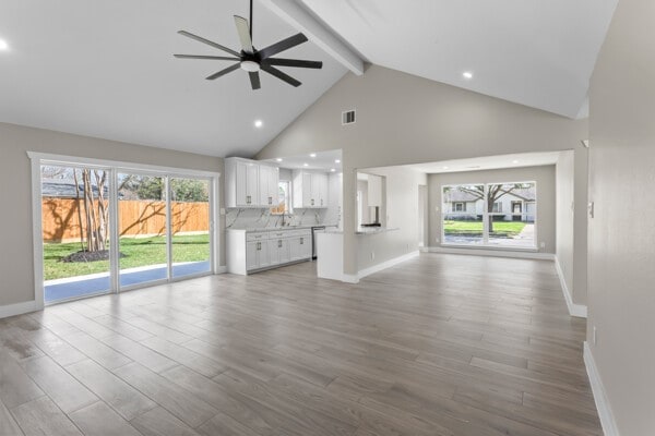 10719 Carlota Ct, Houston, TX 77096 - unfurnished living room featuring beam ceiling, a ceiling fan, high vaulted ceiling, wood finished floors, and recessed lighting