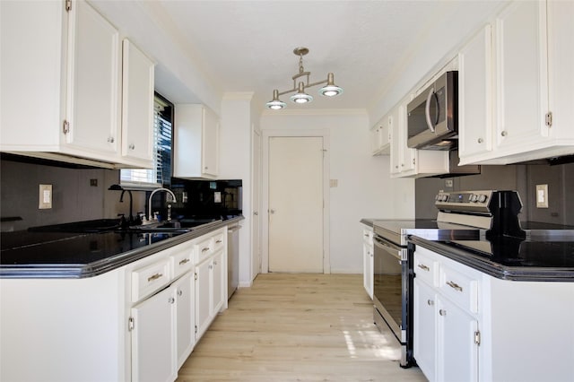 15803 Pryor Dr, Houston, TX 77489 - kitchen featuring stainless steel appliances, a sink, dark countertops, crown molding, and white cabinetry
