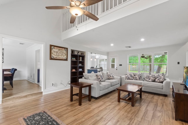9222 New Forest Rd, Spring, TX 77379 - living room featuring a ceiling fan, light wood finished floors, a towering ceiling, baseboards, and recessed lighting