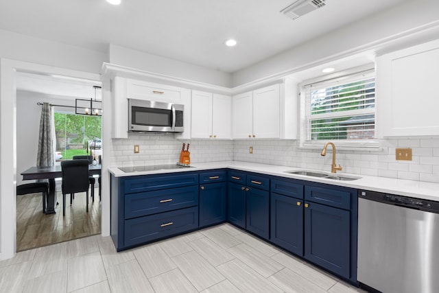 9222 New Forest Rd, Spring, TX 77379 - kitchen featuring stainless steel appliances, a sink, blue cabinetry, white cabinetry, and recessed lighting