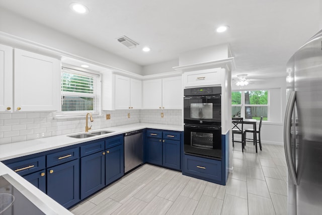 9222 New Forest Rd, Spring, TX 77379 - kitchen featuring appliances with stainless steel finishes, a sink, white cabinetry, blue cabinetry, and recessed lighting