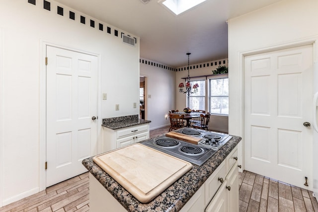 18 Village Hill Dr, Conroe, TX 77304 - kitchen featuring electric cooktop, white cabinetry, light wood finished floors, and hanging light fixtures