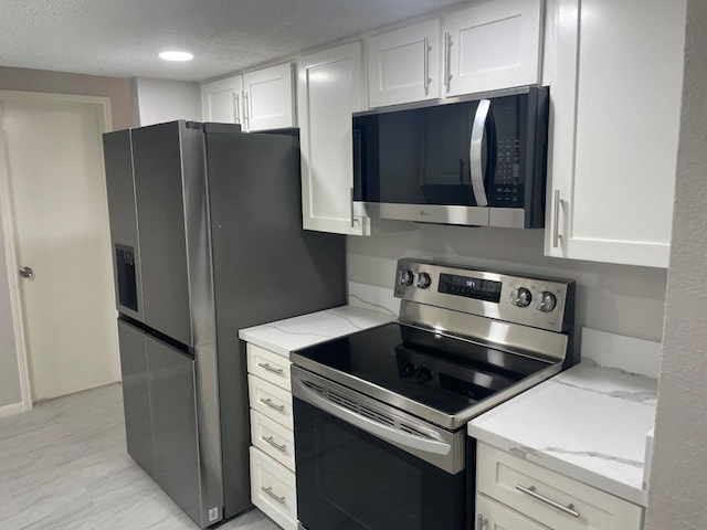 19414 Leafwood Ln, Houston, TX 77084 - kitchen with appliances with stainless steel finishes, white cabinets, light stone countertops, and a textured ceiling