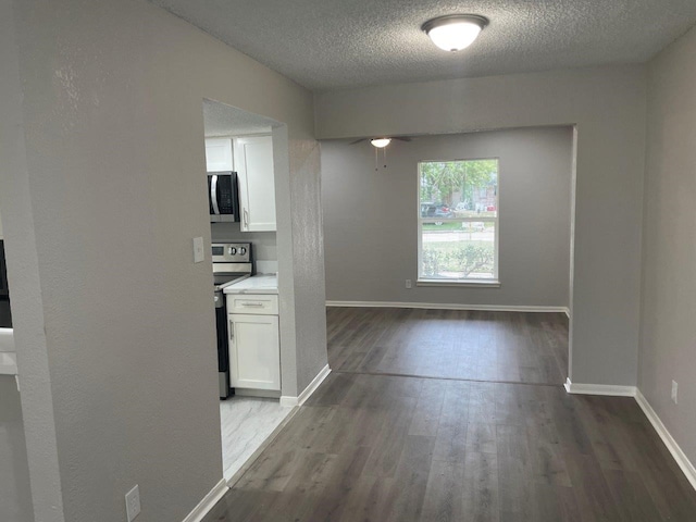 19414 Leafwood Ln, Houston, TX 77084 - hallway with a textured ceiling, dark wood-style floors, and baseboards