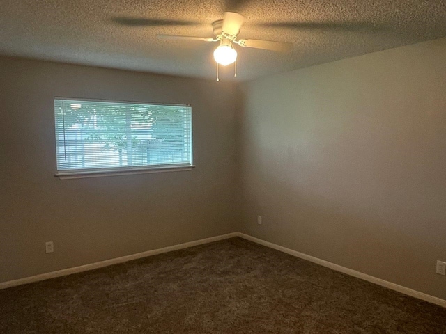 19414 Leafwood Ln, Houston, TX 77084 - empty room featuring dark colored carpet, a ceiling fan, a textured ceiling, and baseboards