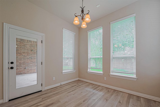 5442 Jackson Park Ln, Katy, TX 77494 - unfurnished dining area with light wood-type flooring, a chandelier, and baseboards