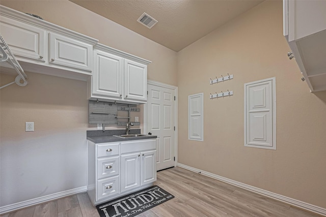 5442 Jackson Park Ln, Katy, TX 77494 - kitchen featuring a sink, baseboards, white cabinets, and light wood finished floors