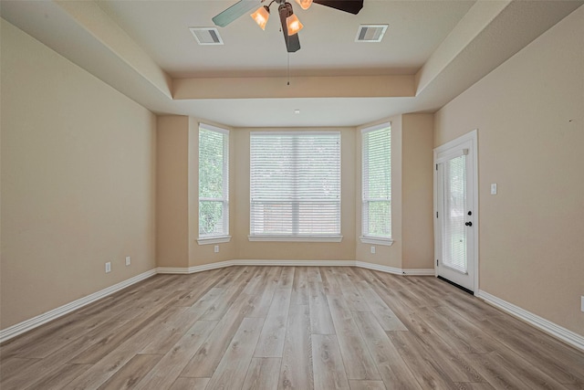 5442 Jackson Park Ln, Katy, TX 77494 - empty room with a raised ceiling, light wood-style flooring, a ceiling fan, and healthy amount of natural light